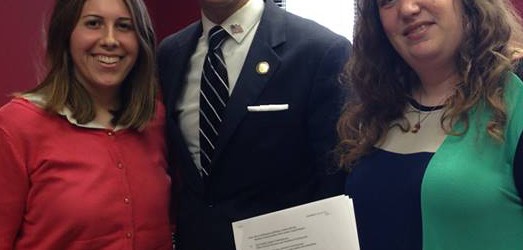 Left to right: Rebecca Botta-Zalucki, Assemblyman Santabarbara, and Henny Kupferstein, holding the signed proposal.